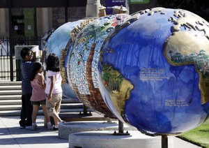 Visitors to the Rose Garden at Exposition Park view one of 50 globes, part of a public art project,