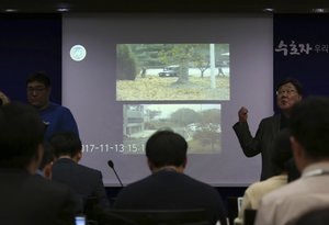 Journalists watch CCTV footage regarding a North Korean soldier's defection, during a press conference at the Defense Ministry in Seoul, South Korea, Wednesday, Nov. 22, 2017