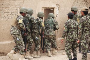 Soldiers with the 215th Corps, Afghan National Army, forcefully enter a simulated enemy-occupied compound during a Military Operations in Urban Terrain training exercise aboard Camp Bastion, Afghanistan, March 8, 2014