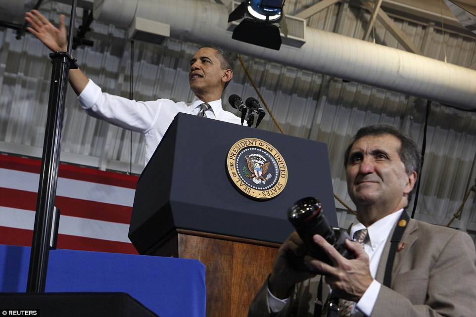 Barack Obama talks about American energy while his official photographer Pete Souza stands in front the podium at Prince George's Community College in Largo, Maryland, March 15, 2012