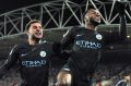 Manchester City's Raheem Sterling (right) celebrates with teammate Kyle Walker after scoring against Huddersfield Town.