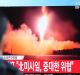 A man watches a TV screen showing a local news program reporting with a file footage of North Korea's missile launch, at ...