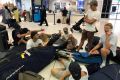 A group of surfers from Sydney wait for updates on their cancelled flight.