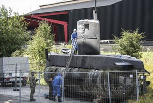 Police technicians board the amateur-built submarine UC3 Nautilus on a pier in Copenhagen harbour, Denmark, Monday morning, Aug. 14, 2017, to conduct forensic probes in connection with a murder investigation.