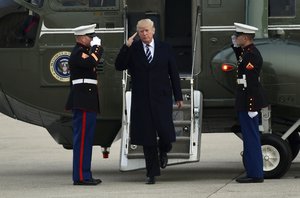 President Donald Trump salutes as he steps off of Marine One and walks towards Air Force One at John F. Kennedy International Airport in New York, Saturday, Dec. 2, 2017.