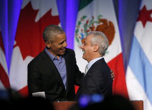 Former President Barack Obama, left, shares a laugh with Chicago Mayor Rahm Emanuel after Emanuel introduced Obama at a summit on climate change involving mayors from around the globe Tuesday, Dec. 5, 2017, in Chicago.