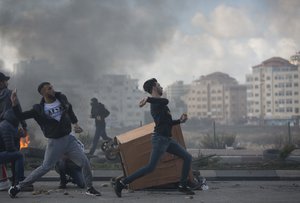 Palestinian protesters clash with Israeli troops following protests against U.S. President Donald Trump's decision to recognize Jerusalem as the capital of Israel, in the West Bank city of Ramallah, Thursday, Dec. 7, 2017.