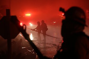 Fire crews work among destroyed homes at the Rancho Monserate Country Club community Thursday, Dec. 7, 2017, in Fallbrook, California.