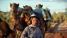 Writer Robyn Davidson is photographed with her camels and dog Diggity for National Geographic in 1977 in outback Australia.