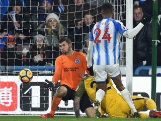 Brighton's Australian goalkeeper Mathew Ryan (L) makes a save during the English Premier League football match between Huddersfield Town and Brighton and Hove Albion at the John Smith's stadium in Huddersfield, northern England on December 9, 2017. / AFP PHOTO / Oli SCARFF / RESTRICTED TO EDITORIAL USE. No use with unauthorized audio, video, data, fixture lists, club/league logos or 'live' services. Online in-match use limited to 75 images, no video emulation. No use in betting, games or single club/league/player publications. /