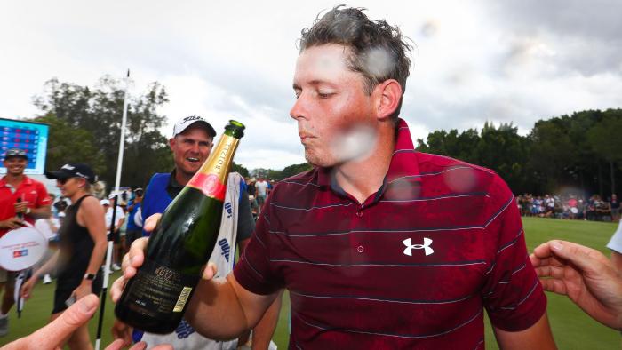 Golfer Cameron Smith of Australia (C) has a drink of champagne following his victory in the Australian PGA Championship golf tournament at the Royal Pines Resort on the Gold Coast on December 3, 2017. / AFP PHOTO / Patrick HAMILTON / --IMAGE RESTRICTED TO EDITORIAL USE - STRICTLY NO COMMERCIAL USE--