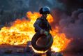 Israeli border police officer clears a burning tire during clashes with Palestinian protesters following protests ...