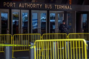 Heavily armed police stands guard in front of Port Authority Bus Terminal as police respond to a report of an explosion near Times Square on Monday, Dec. 11, 2017, in New York.