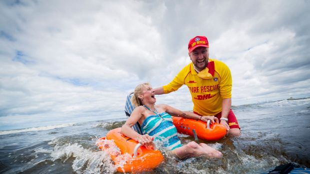 9/12/17 Amanda Laurie-Jones enjoys a swin with St Kilda life saver Simon Lewis. Port Phillip Council has bought beach ...