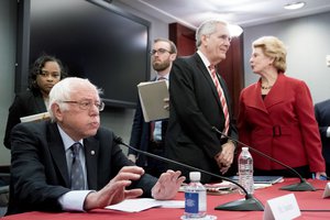 From left, Sen. Bernie Sanders, I-Vt., Rep. Lloyd Doggett, D-Texas, and Sen. Debbie Stabenow, D-Mich. and other House and Senate conferees gather after GOP leaders announced they have forged an agreement on a sweeping overhaul of the nation's tax laws, on Capitol Hill in Washington, Wednesday, Dec. 13, 2017.