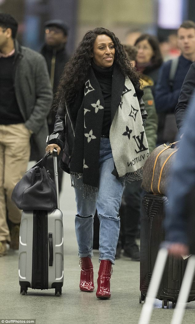 Giddy: She was smiling broadly as she made her way through the Eurostar terminal, seemingly hiding her ring finger on her left hand