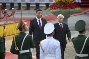 File - Chinese President Xi Jinping, center left, and Vietnam's Communist Party General Secretary Nguyen Phu Trong, center right, review an honor guard during a welcoming ceremony at the presidential palace in Hanoi, Vietnam Sunday, Nov. 12, 2017.