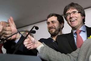 Ousted Catalan leader Carles Puigdemont, right, and former Catalan Health Minister Antoni Comin, left, gesture during a press conference at the Square Meeting Center in Brussels on Thursday, Dec. 21, 2017.