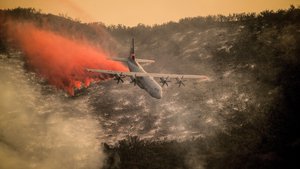 A California Air National Guard C-130J Hercules drops fire retardant over the hills above Santa Barbara, Calif., Dec. 13, 2017, while helping fight the Thomas Fire.