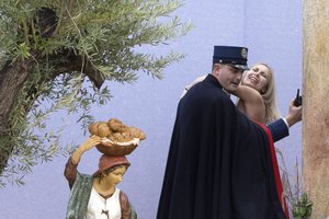 In this Thursday, Dec. 25, 2014 file photo, a gendarme from the Vatican's security forces stops a Ukrainian feminist group Femen activist after she snatched the statue of Baby Jesus from the Nativity scene set in St. Peter's Square at the Vatican.