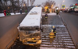 Rescuers to pull a crashed bus out from a subway in Moscow, Russia, Monday, Dec. 25, 2017.