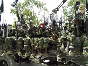 File - In this photo of Thursaday, Oct.21, 2010, Al-Shabaab fighters display weopons as they conduct military exercises in northern Mogadishu, Somalia.