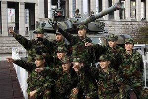 South Korean soldiers pose for photos near a K1 tank on display at the Korea War Memorial Museum in Seoul, South Korea, Thursday, Dec. 23, 2010. South Korean fighter jets dropped bombs and tanks fired artillery Thursday as the military staged its largest air and ground firing drills of the year in a show of force a month after North Korea's deadly shelling of a front-line island.