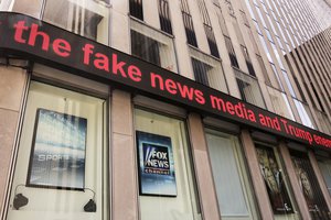 File - News headlines scroll above the Fox News studios in the News Corporation headquarters building in New York, Tuesday, Aug. 1, 2017. Fox contributor Rod Wheeler, who worked on the Seth Rich case, claims Fox News fabricated quotes implicating the murdered Democratic National Committee staffer in the Wikileaks scandal and that President Donald Trump pressured Fox to publish the story.