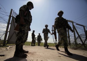 India’s Border Security Force (BSF) soldiers patrol near the India-Pakistan international border fencing at Garkhal, about 35 kilometers (22 miles) west of Jammu, India, Monday, Sep. 16, 2013