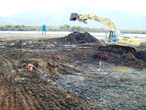 An excavator removes hazardous waste from an old landfill during a restoration project at Naval Base Ventura County, Point Mugu.