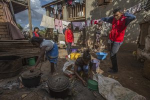 Red Cross volunteers speak to women as they are busy cooking, whilst educating villagers about the plague outbreak, 30 miles west of Antananarivo, Madagascar, Monday, Oct. 16, 2017.