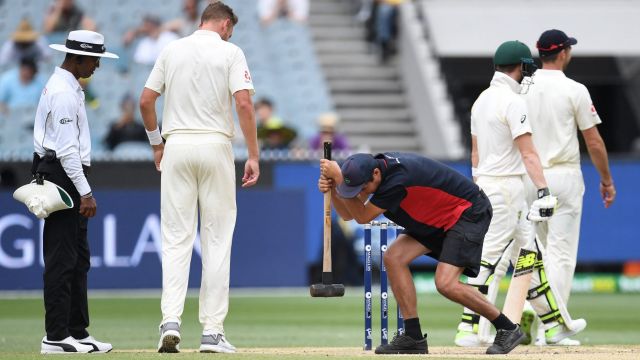 A groundsman takes a sledgehammer to the MCG pitch today. 