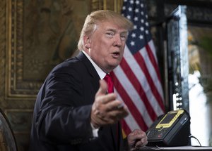 President Donald Trump turns to talk to the gathered media during a Christmas Eve video teleconference with members of the mIlitary at his Mar-a-Lago estate in Palm Beach, Fla., Sunday, Dec. 24, 2017.