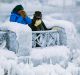 Visitors try to keep warm at the brink of the Horseshoe Falls in Niagara Falls, Ontario, as cold weather continues ...