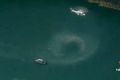 A helicopter hovers over the water near where the seaplane is believed to have gone down. 