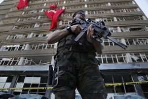 A Turkish special forces policeman stands guard in front the damaged building of the police headquarters which was attacked by the Turkish warplanes during the failed military coup last Friday, in Ankara, Turkey, Tuesday, July 19, 2016.