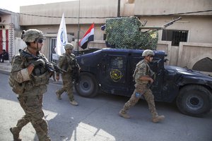 File - U.S. Army Paratroopers, deployed in support of Combined Joint Task Force – Operation Inherent Resolve and assigned to the 2nd Brigade Combat Team, 82nd Airborne Division, walk outside of an Iraqi Federal Police patrol base in Mosul, Iraq, July 4, 2017.