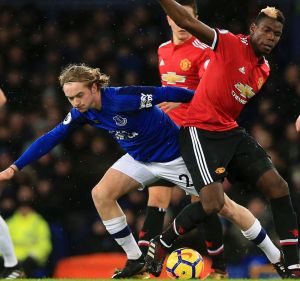 Everton's Tom Davies and Manchester United's Paul Pogba battle for the ball.