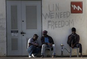 File - African migrants sit outside Holot detention center in the Negev Desert, southern Israel, Tuesday, April 21, 2015. Tens of thousands of African migrants have made their way to Israel in recent years.