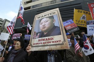 In this Monday, Nov. 6, 2017, file photo, an anti-North Korea protester holds up a portrait of North Korean leader Kim Jong Un during a rally welcoming the visit by U.S. President Donald Trump near the U.S.