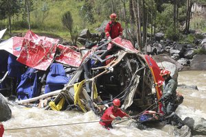 Firemen recover a body from the wreck·age of a bus, in Trujillo, Peru, Saturday, April 13, 2013. Police say the passenger bus plunged off an Andean highway into a river, killing at least 27 people.