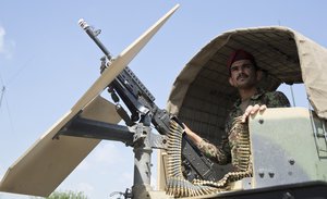 In this Wednesday, Aug. 5, 2015 file photo, an Afghanistan's National Army soldier stands guard in his vehicle in Camp Khogyani in Nangarhar province, east of Kabul, Afghanistan. Homegrown militants loyal to the Islamic State group are making inroads into Afghanistan, controlling territory in some parts of the country and ruling with the harsh hand the group is notorious for in Iraq and Syria, according to officials, military leaders and analysts.