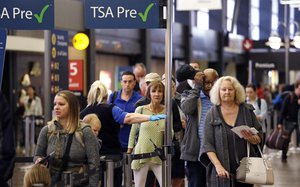 In this photo taken Thursday, April 6, 2017, passengers at a TSA pre-check line are directed to a different line to go through a security check-point at Seattle-Tacoma International Airport, in SeaTac, Wash