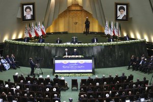 Iran's President Hasan Rouhani, bottom right, swears-in for the second term in office, as he stands next to judiciary chief Sadeq Larijani, bottom left, at the parliament in Tehran, Iran, Saturday, Aug. 5, 2017.