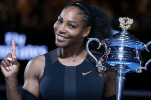 FILE - In this Jan. 28, 2017, file photo, Serena Williams holds up a finger and her trophy after defeating her sister, ...