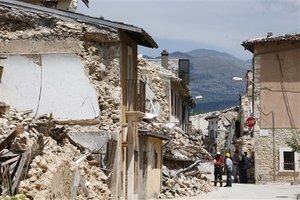 Firemen secure a way in the village of Onna near L' Aquila, Italy, on the eve of the G8 Summit, Tuesday, July 7 2009. German Chancellor Angela Merkel and Italian Prime Minister Sivio Berlusconi are scheduled to visit this village three months after a devastating earthquake on Wednesday. Leaders of the Group of Eight will push for common positions on promoting democracy in Iran, combatting climate change and coordinating their exits from huge government stimulus measures, even amid a growing sense that the group's pre-eminence may be fading.