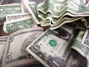 A tip jar contains one dollar and five dollar bills in cash, Sept. 6, 2017 in New York.