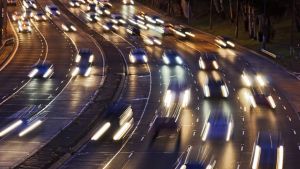 Short headlamps of incoming torrent of cars on multi lane Warringah freeway going across the city of Sydney, Australia, ...