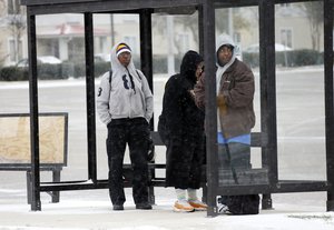 Richard Robinson of Jackson, right, and others wait under a shelter for their morning bus ride into downtown Jackson, Miss., Tuesday, Jan. 28, 2014