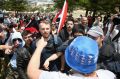 A man wearing an Aussie flag hat clashes with people from the anti-racism rally during the march along the beach in ...